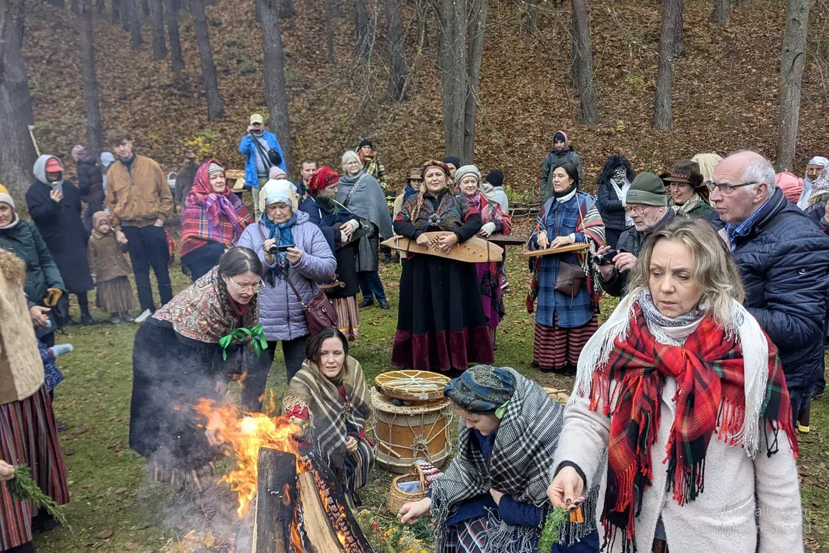Apmeklētāji tautas tērpos pie Mārtiņdienas ugunskura Etnogrāfiskajā brīvdabas muzejā, Rīgā.