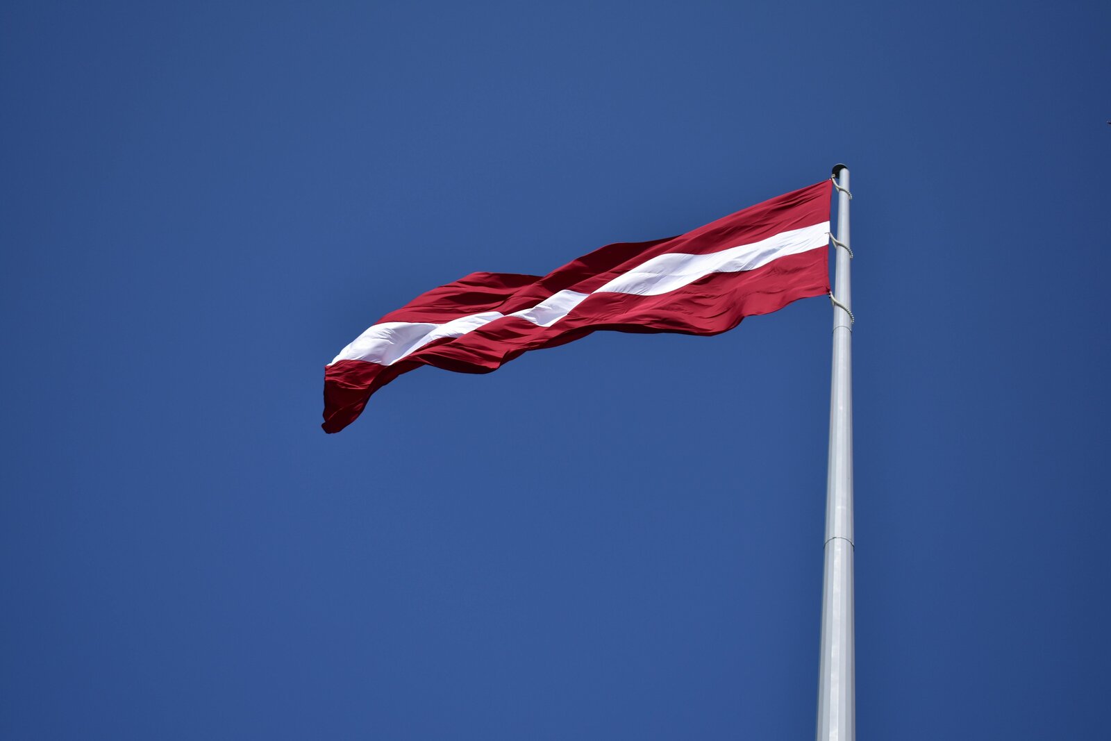 Latvijas karogs zilās debesīs