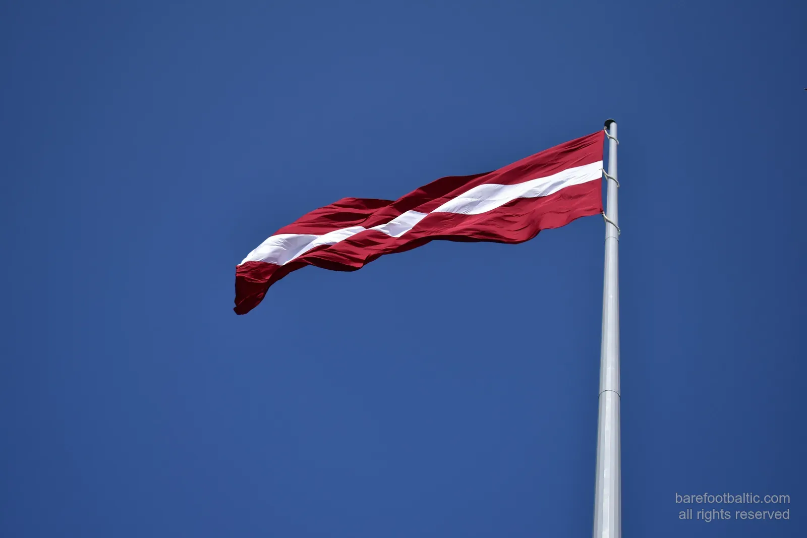 Latvijas karogs zilās debesīs