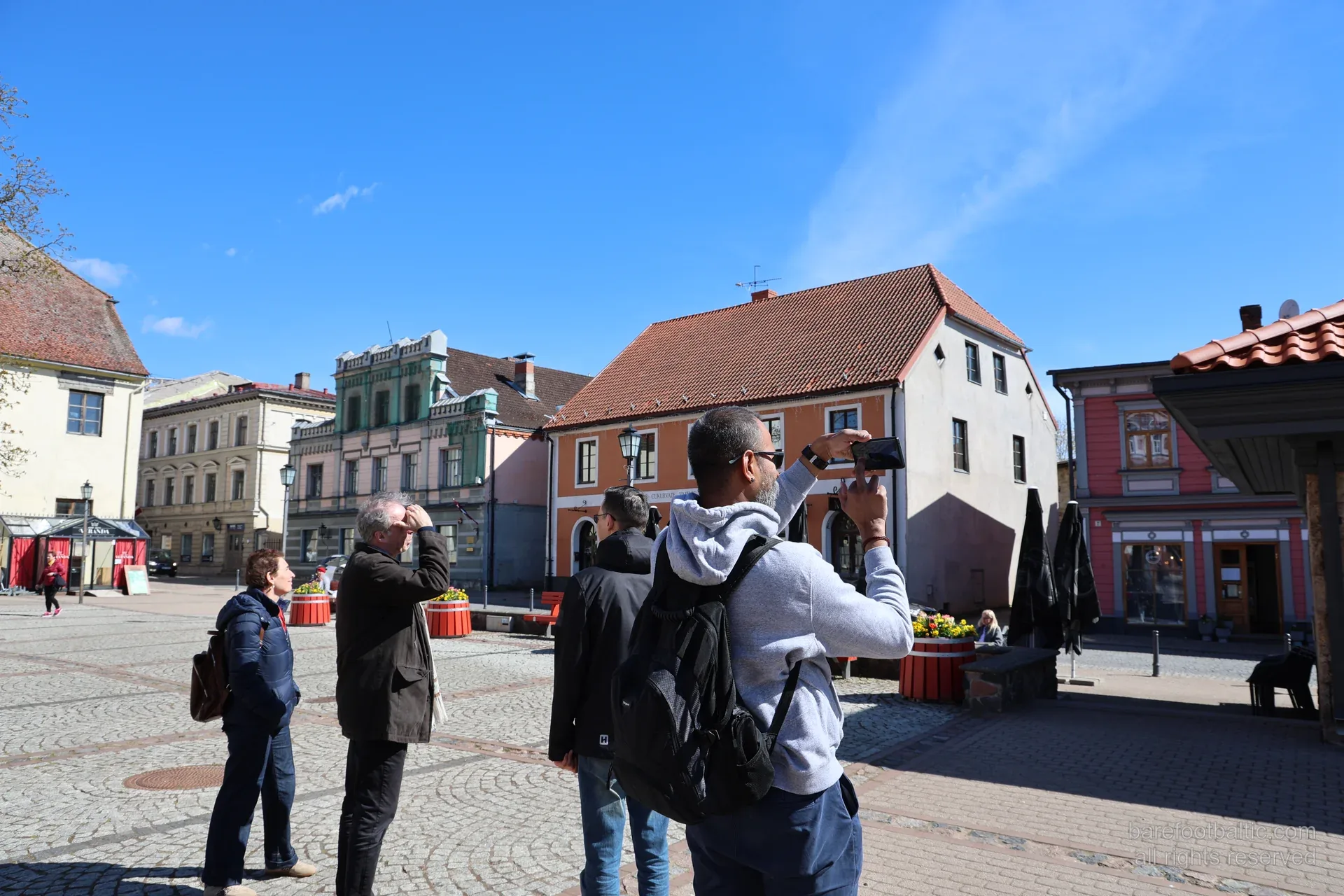 Grupa fotografē vēsturiskās fasādes Cēsu vecpilsētas laukumā