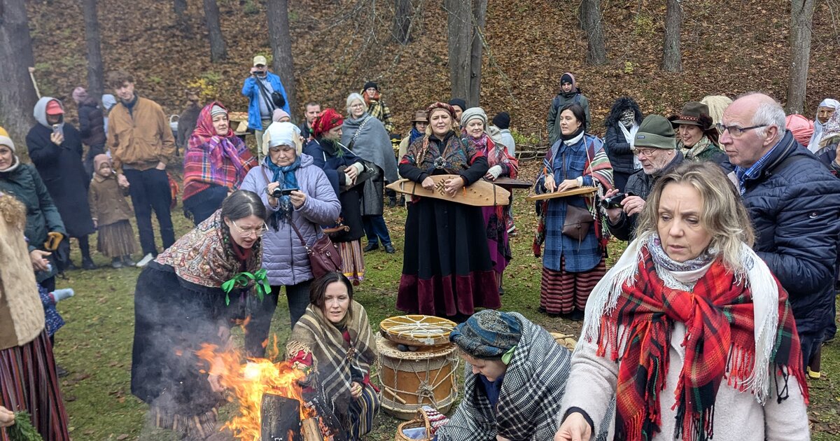 Apmeklētāji tautas tērpos pie Mārtiņdienas ugunskura Etnogrāfiskajā brīvdabas muzejā, Rīgā.