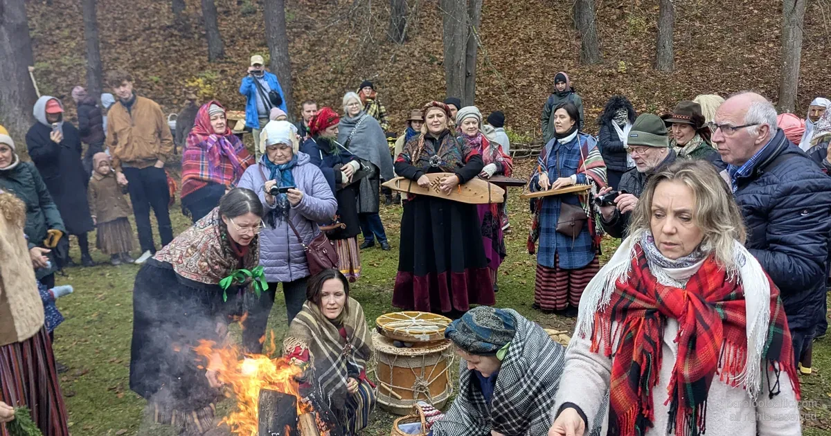Apmeklētāji tautas tērpos pie Mārtiņdienas ugunskura Etnogrāfiskajā brīvdabas muzejā, Rīgā.