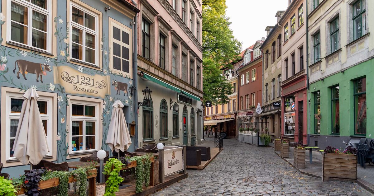 Bruģēta iela ar restorāniem Vecrīgā.